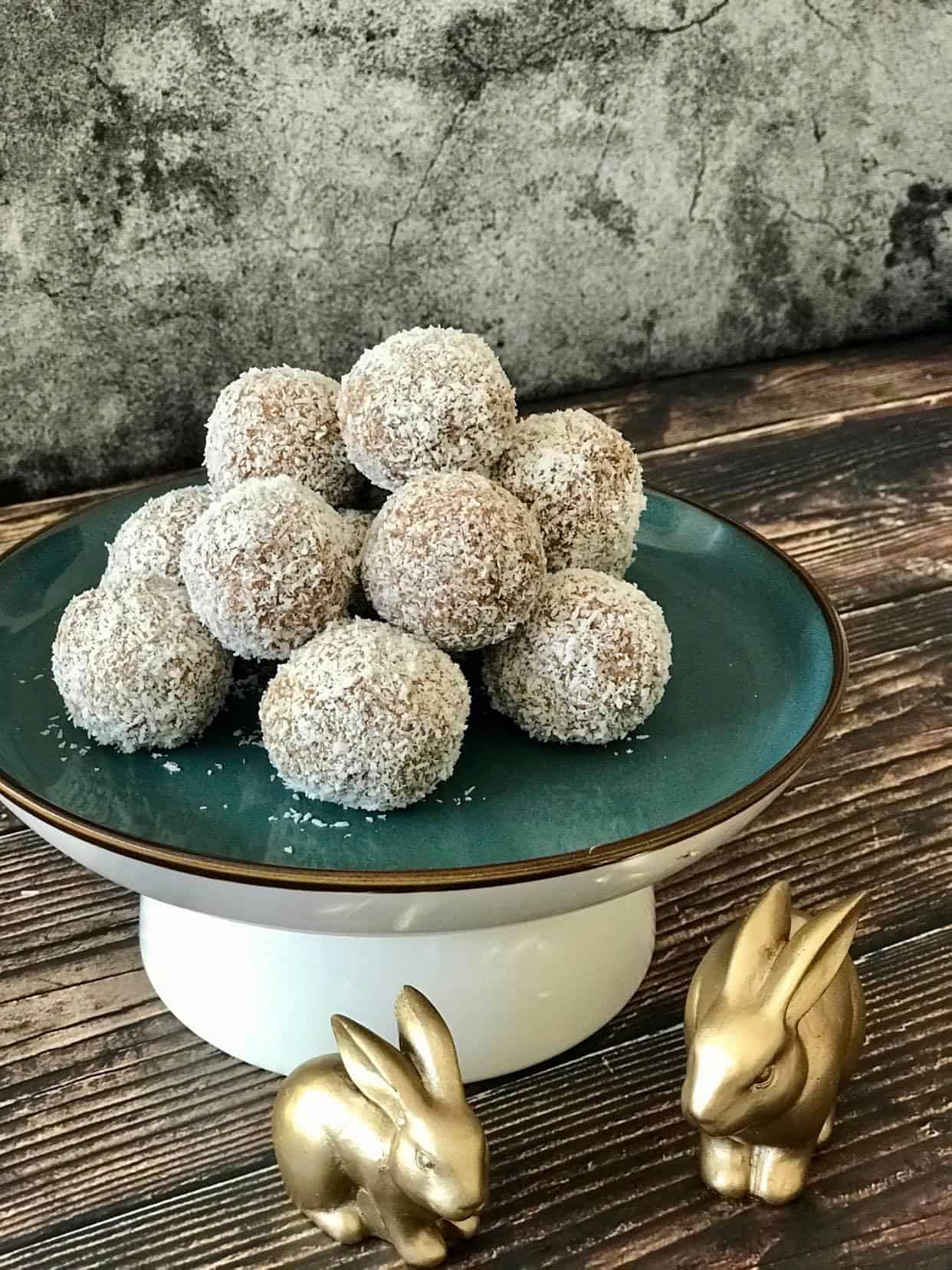 No-bake carrot cake bites on a plate with two bunny figurines.