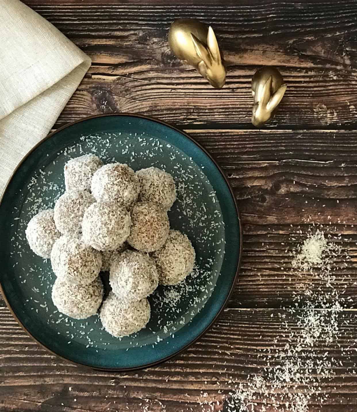 No-bake carrot cake bites on a plate with two bunny figurines.