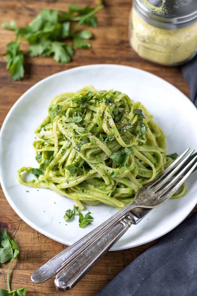 Green goddess pasta on a plate with a fork and knife.