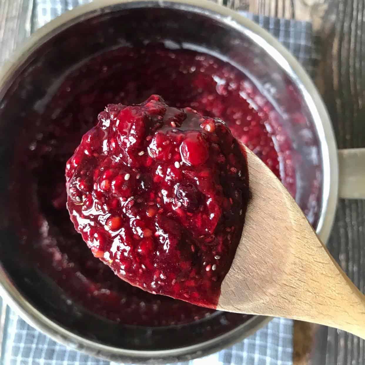 Spoon lifting out the chia berry jam.