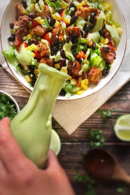 Vegan cilantro-lime dressing being poured over a salad.