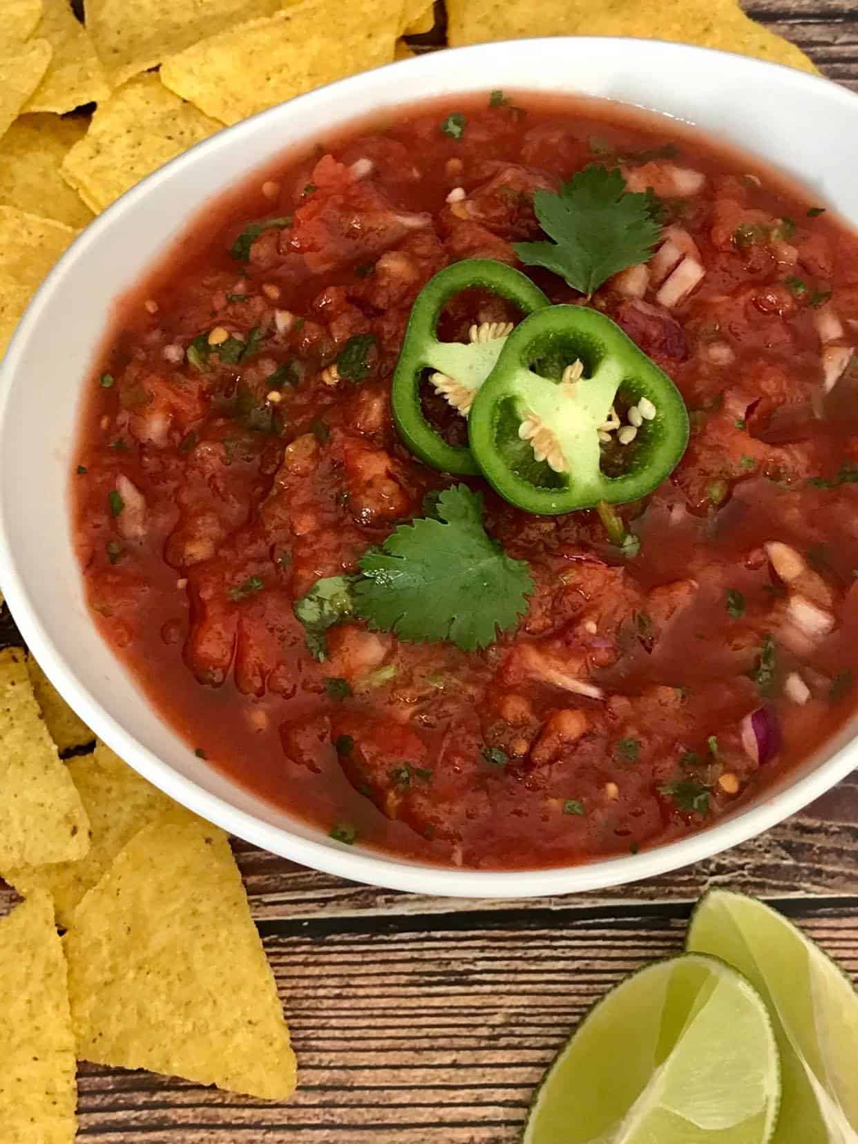 Restaurant-style salsa in a bowl surrounded by tortilla chips.