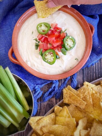 Vegan Cashew Queso in bowl with chips and celery.