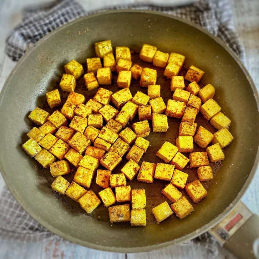 Seared tofu cubes in a skillet.