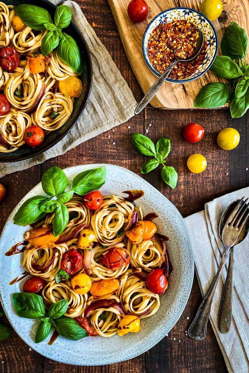 Two bowls of cherry tomato basil pasta.