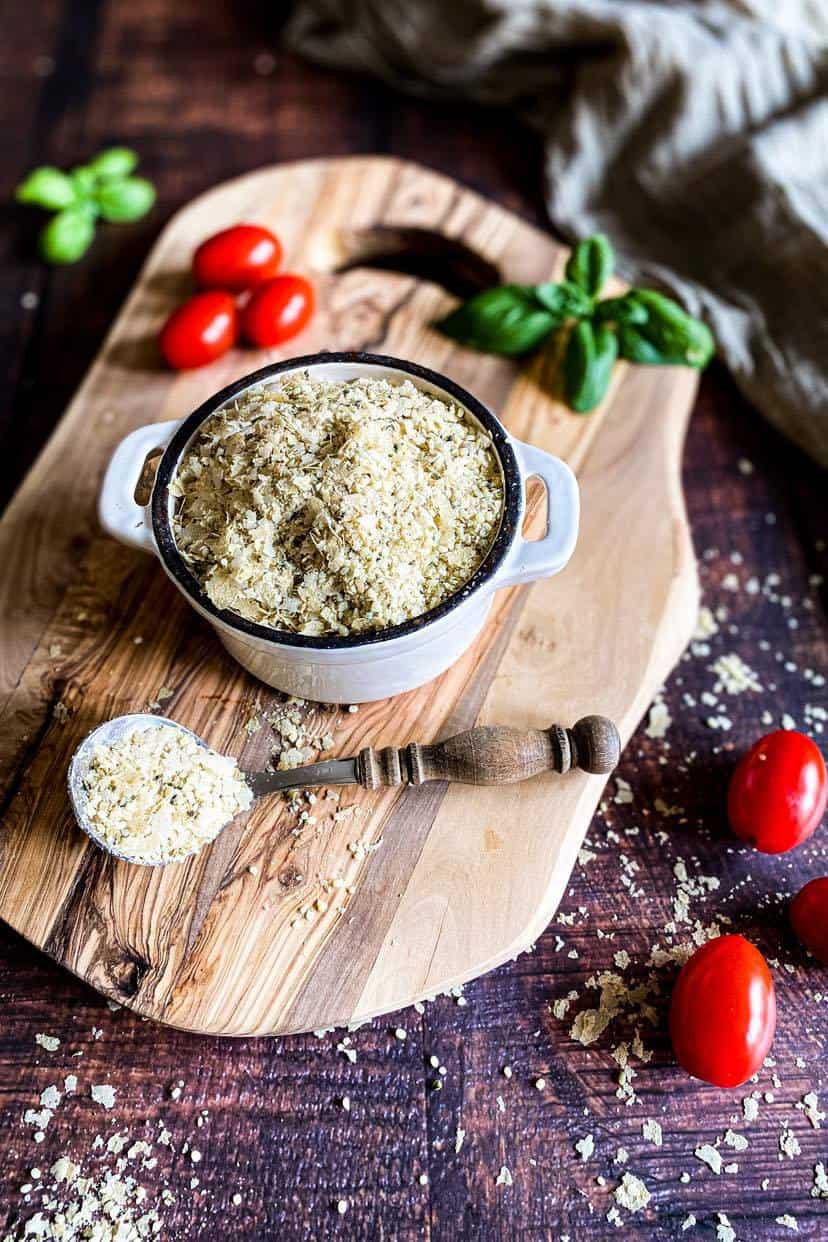 Bowl of vegan parmesan on a cutting board.