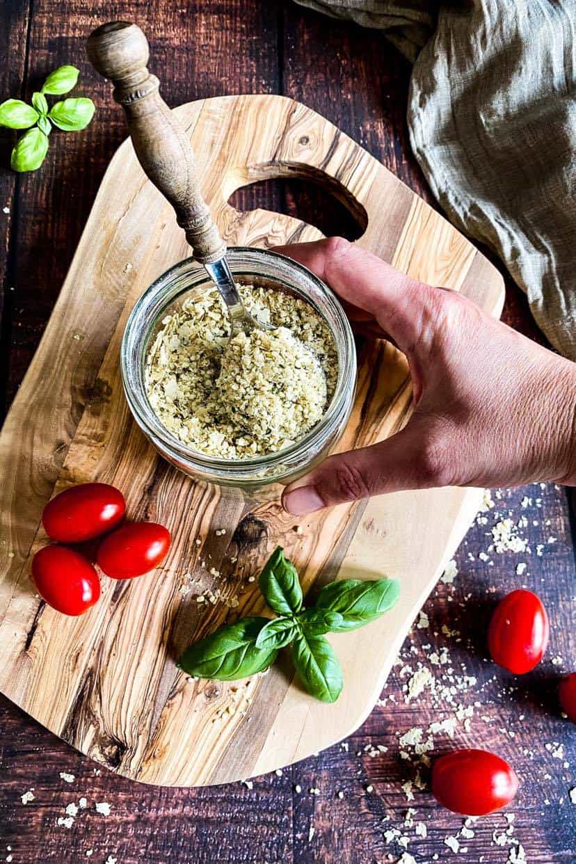 Hand holding a jar of vegan parmesan.