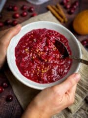 Vegan cranberry sauce in a bowl with a spoon.