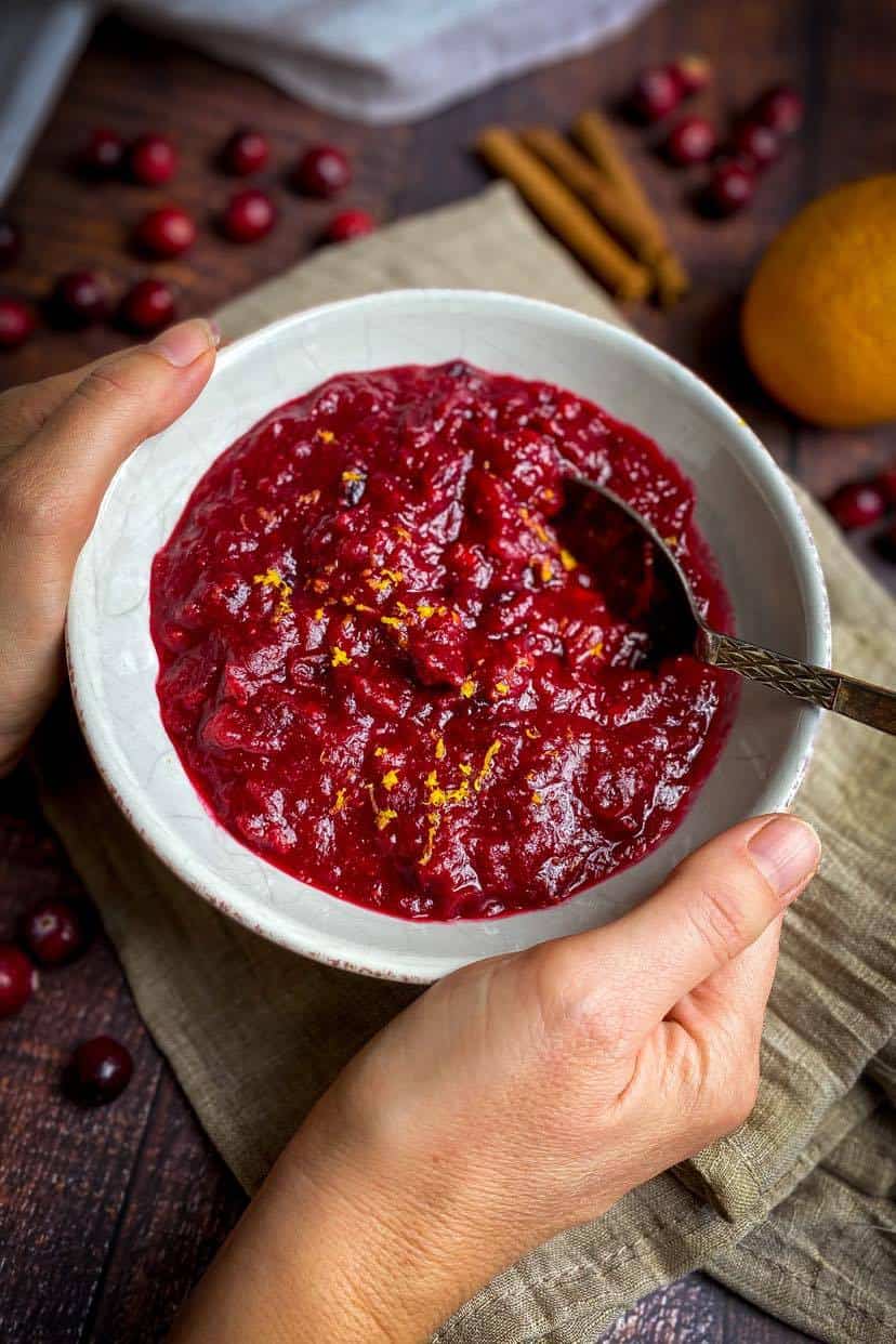 Vegan cranberry sauce in a bowl with a spoon.