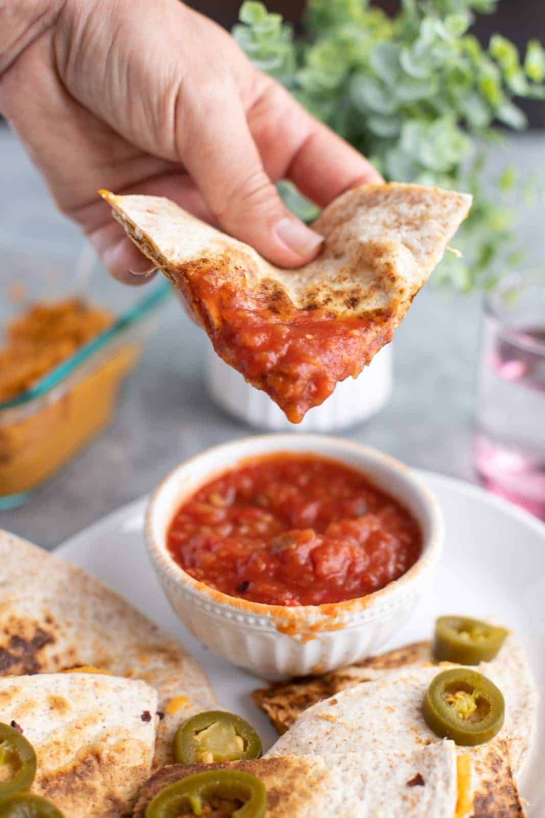 Red pepper hummus quesadilla dipped in salsa.