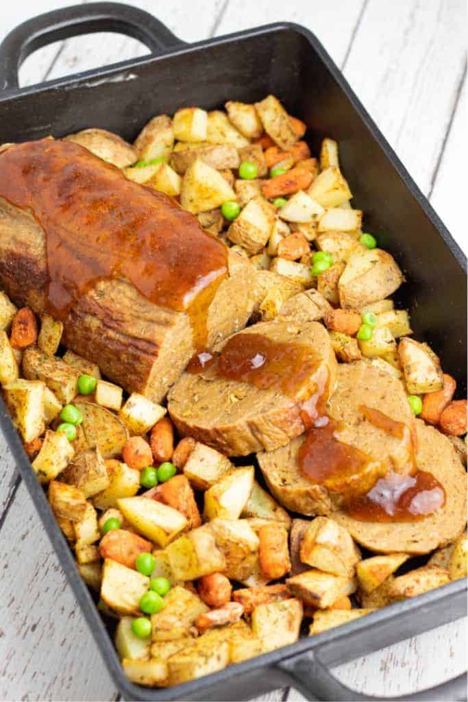 Vegan seitan roast on a bed of roasted vegetables.