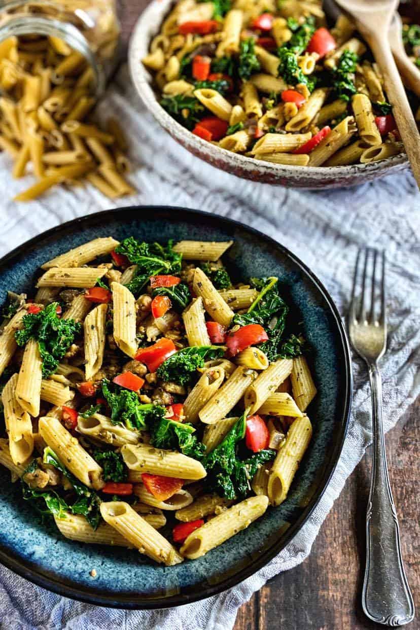 Vegan Penne pasta in bowl with kale and vegan Italian sausage.