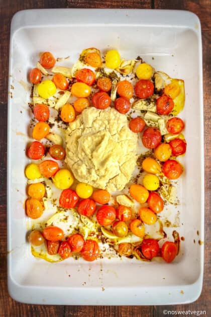 Baked tomatoes and vegan ricotta in a dish.