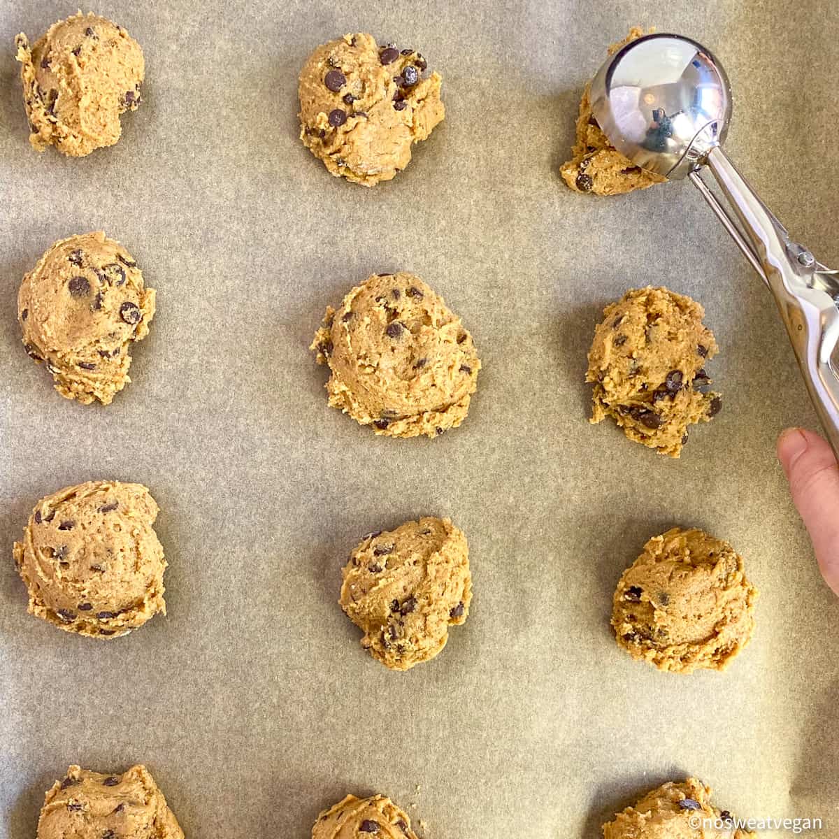 Use an ice cream scoop or two spoons to transfer the vegan cookie dough onto the lined baking sheets.