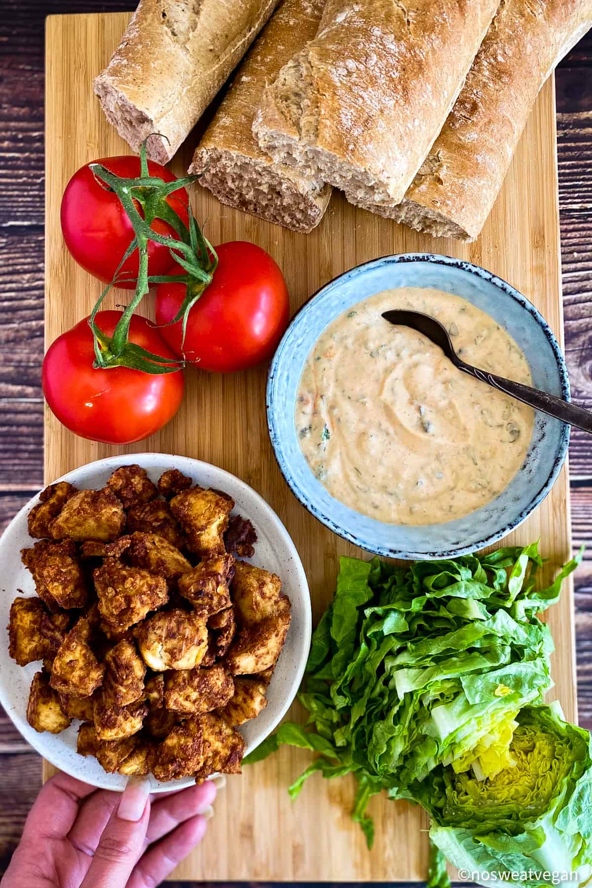 Ingredients to make a vegan po boy: Bread, tomatoes, remoulade, tofu, and lettuce.