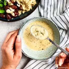 Hummus salad dressing in a little bowl with a spoon.