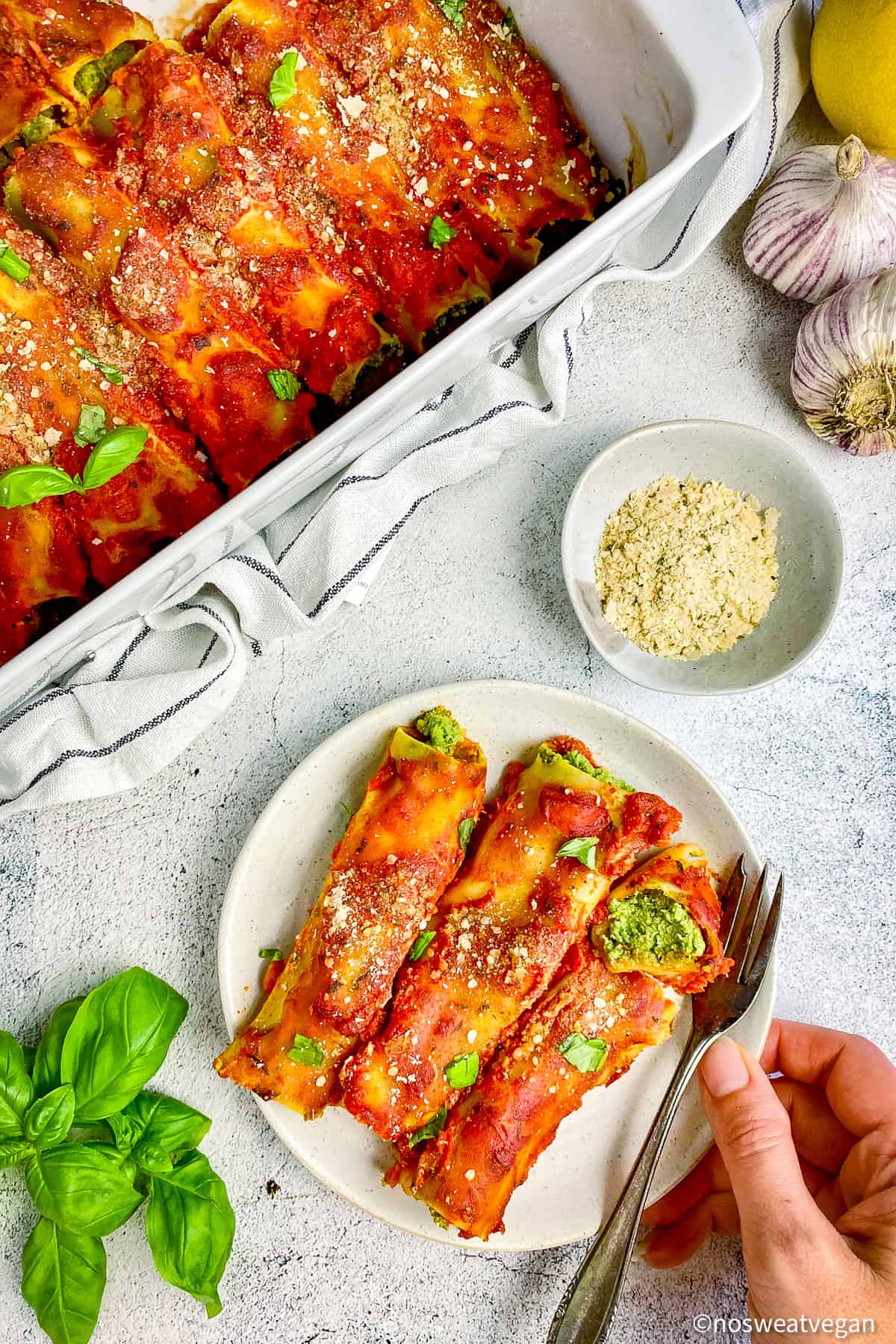 Spinach and ricotta cannelloni on plate with fork.