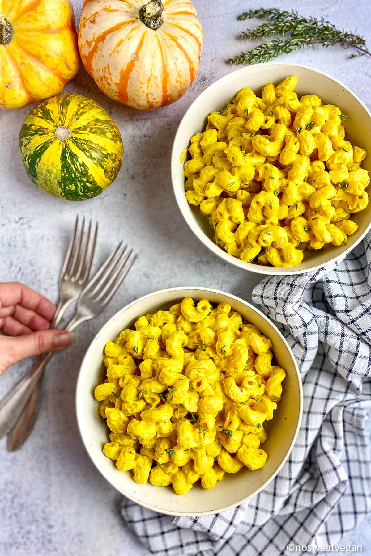 Pumpkin mac and cheese in two bowls with forks on the side.