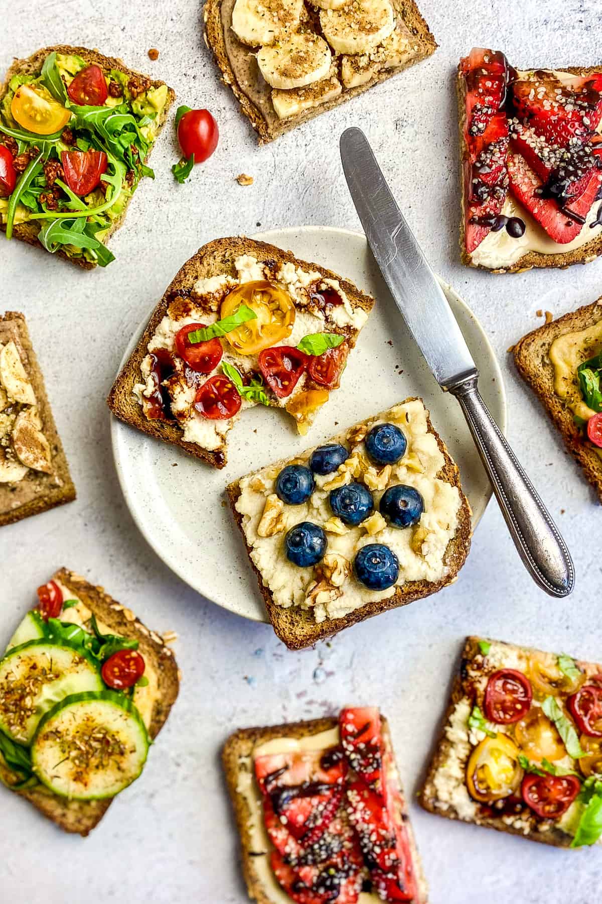 Multiple toast topping ideas with 2 on plate next to a knife.