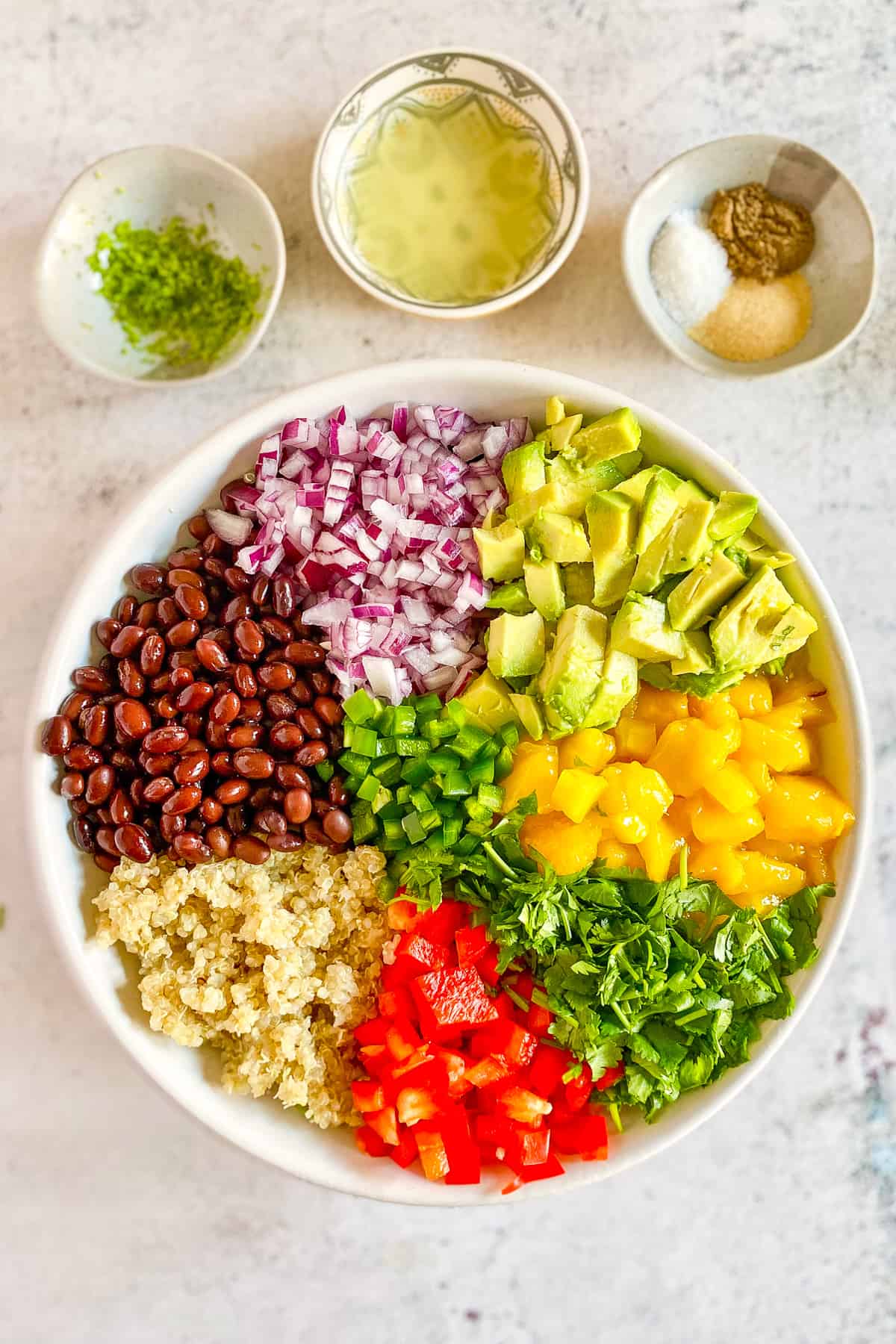 Vegan quinoa salad with avocado, onion, beans, cilantro, jalapeno, and red bell pepper.