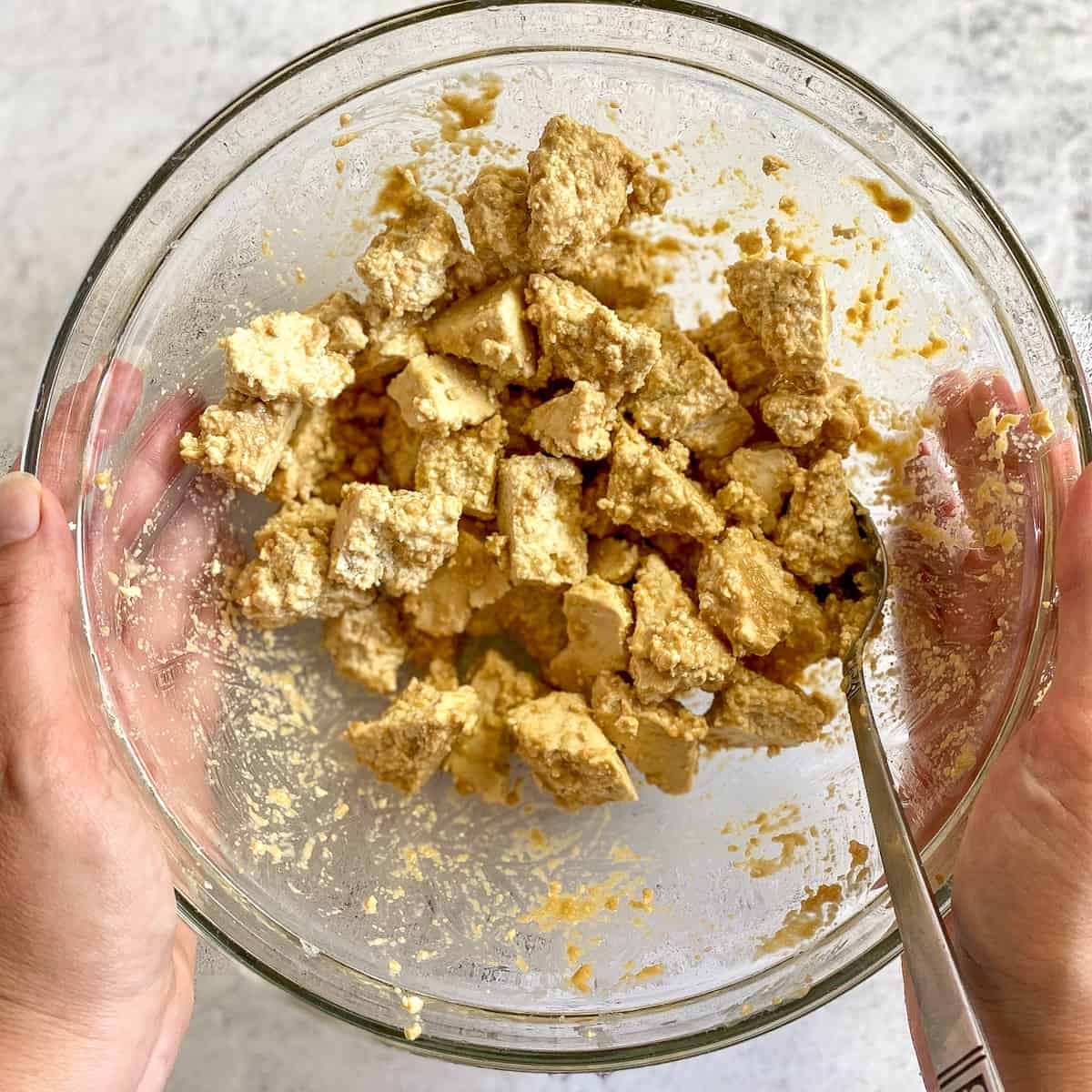 Tofu chunks mixed with paste in a bowl.