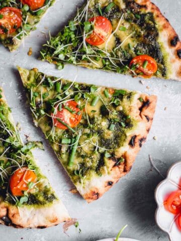 Green pizza sauce on vegan pizza.
