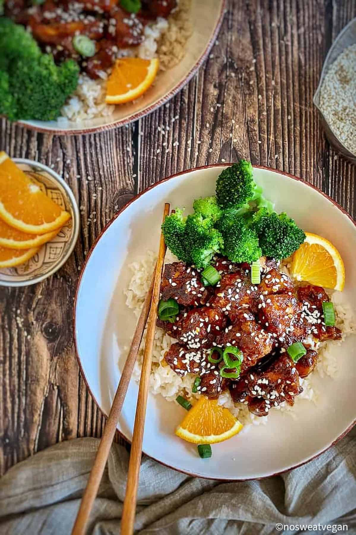 Orange tofu and broccoli in a bowl.