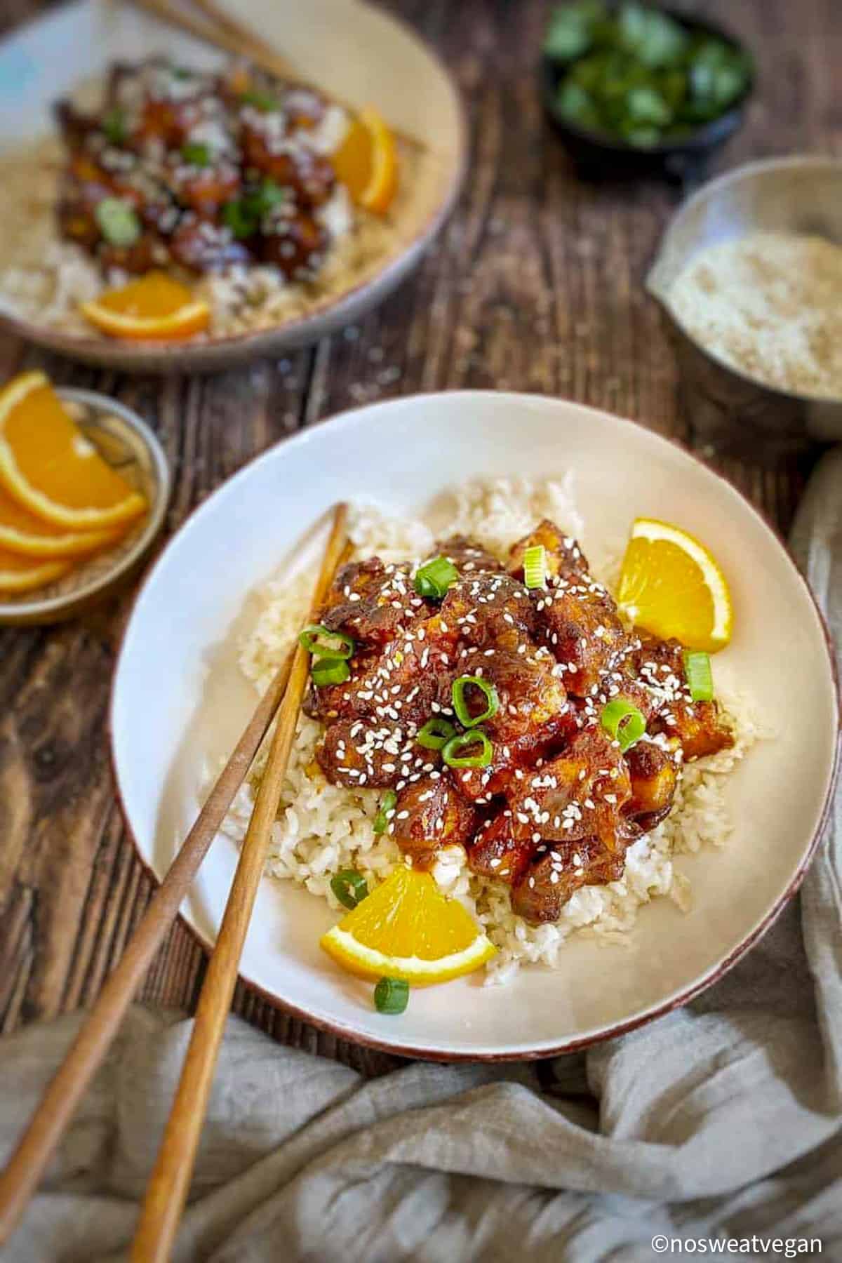 Vegan orange chicken over rice in a bowl.
