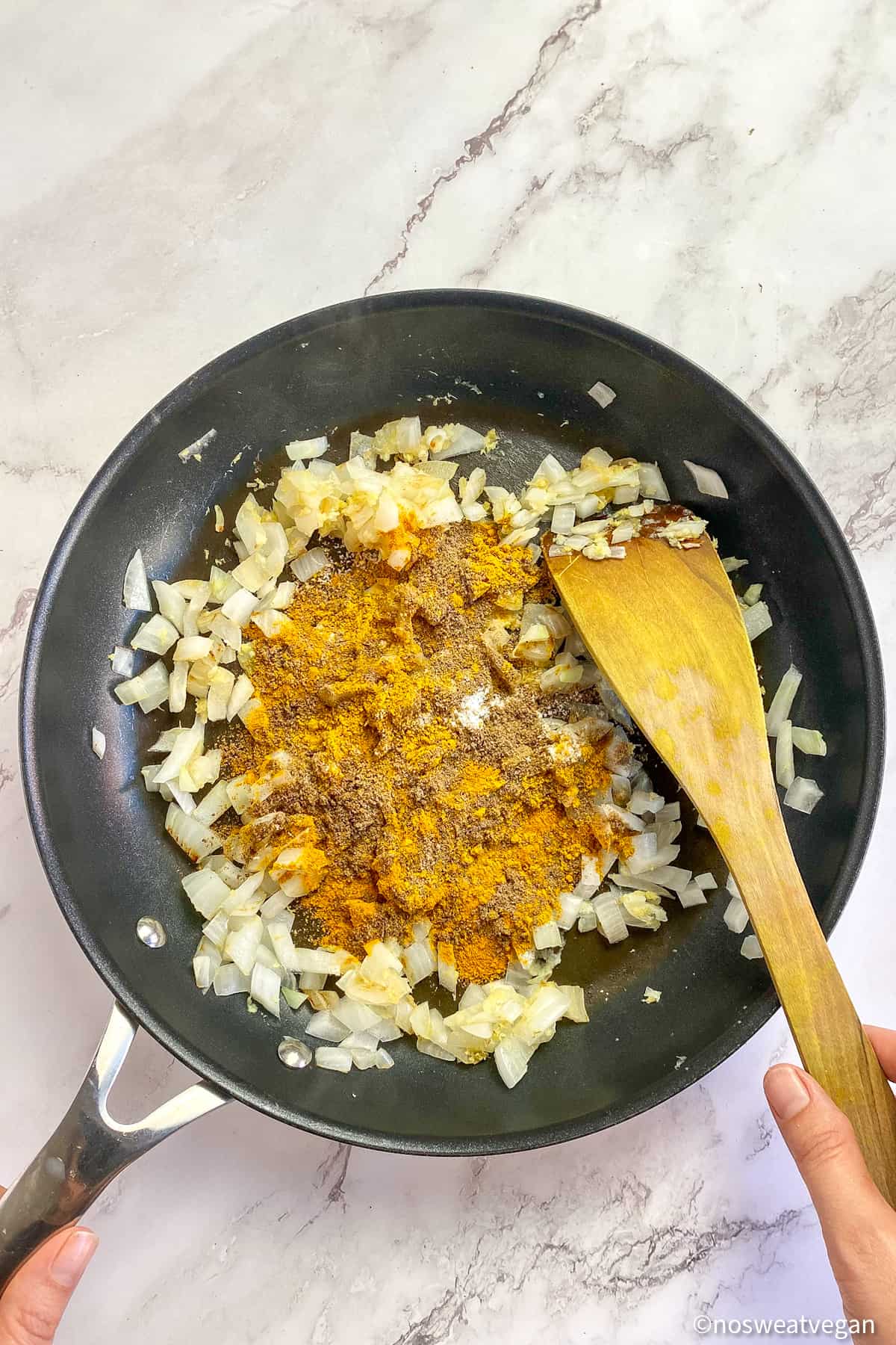Spices and onions in a skillet.