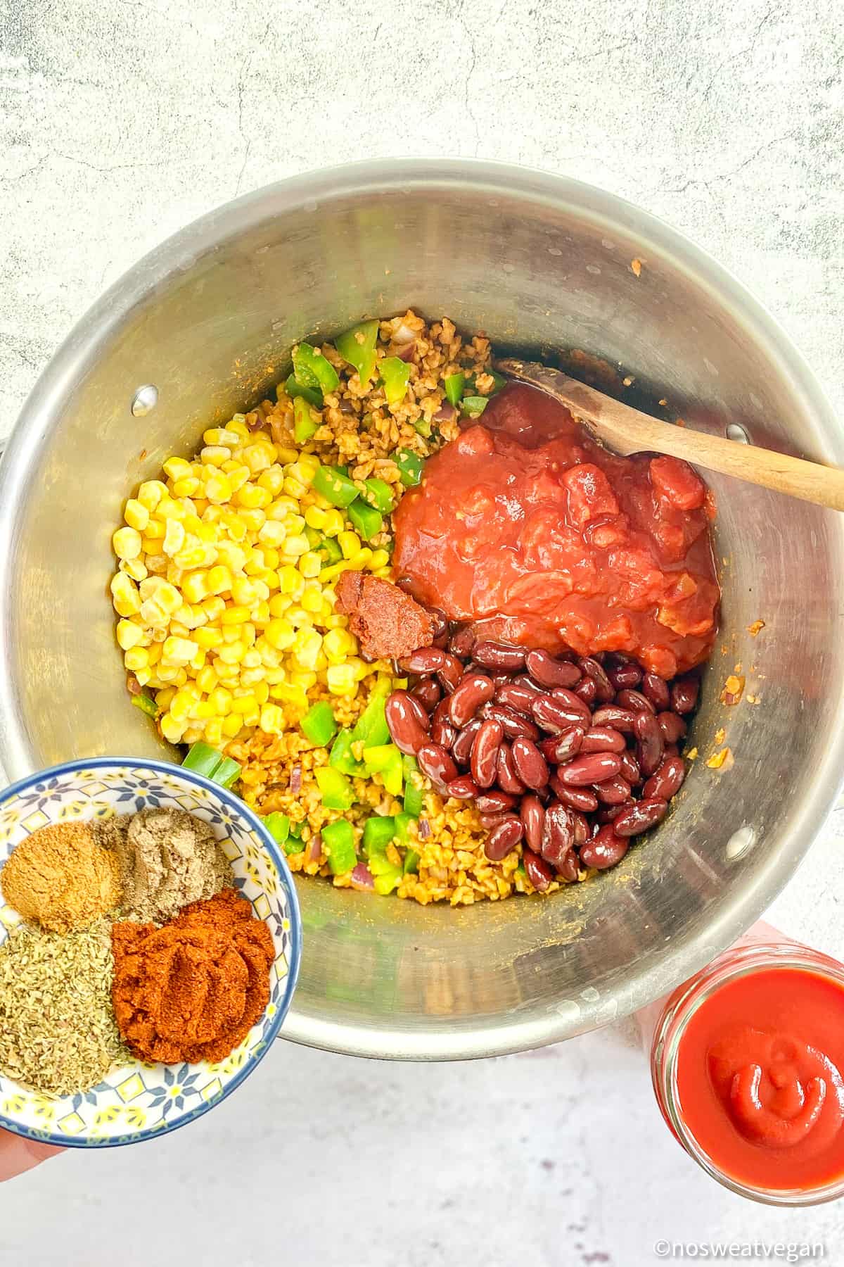 Pot with chili, corn, tomatoes, beans, and spices.