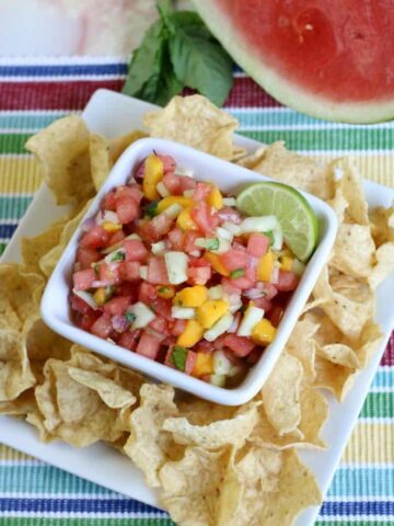 Watermelon salsa in a dish next to chips.