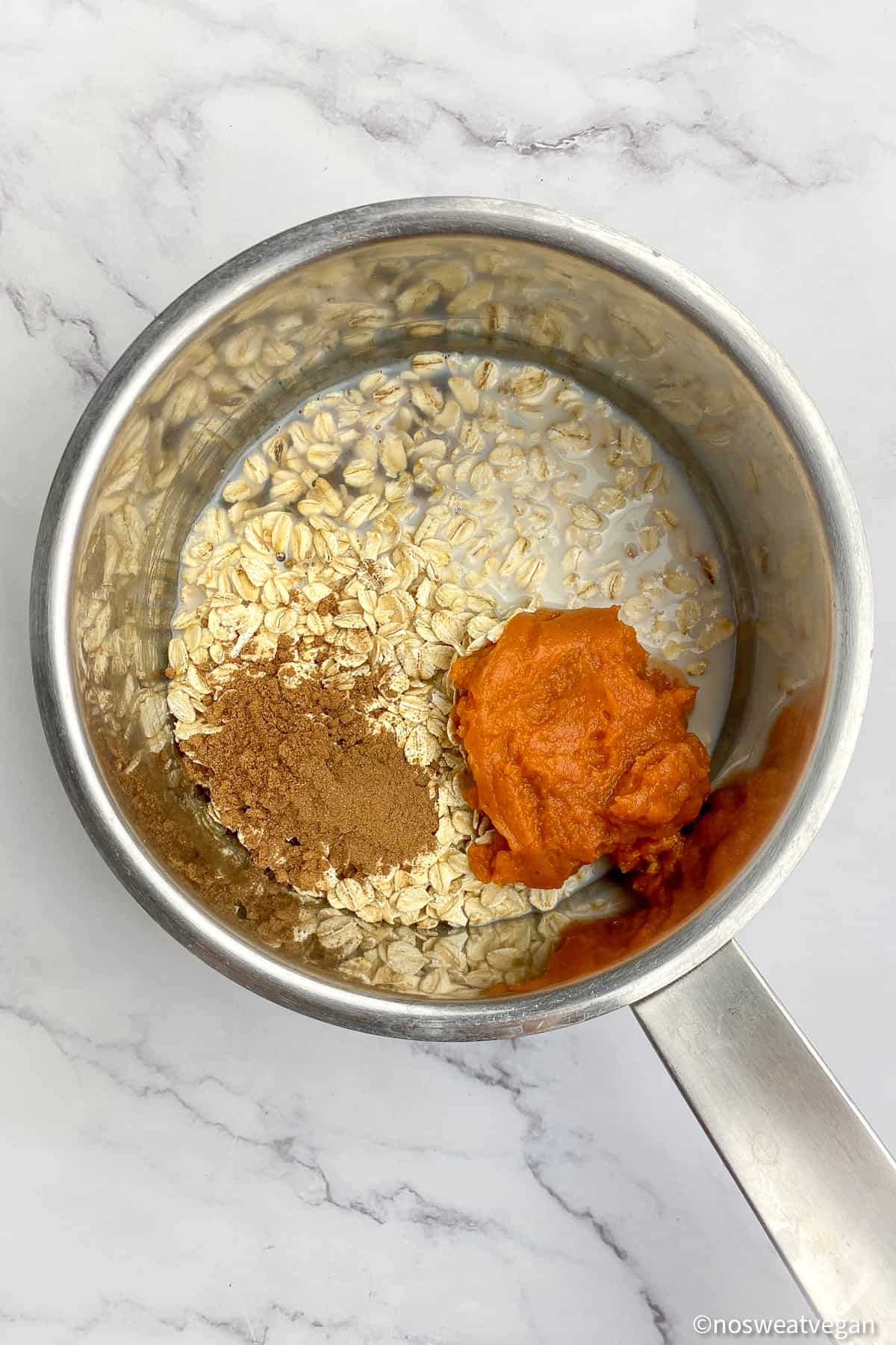 Vegan pumpkin oatmeal ingredients in a small pot.