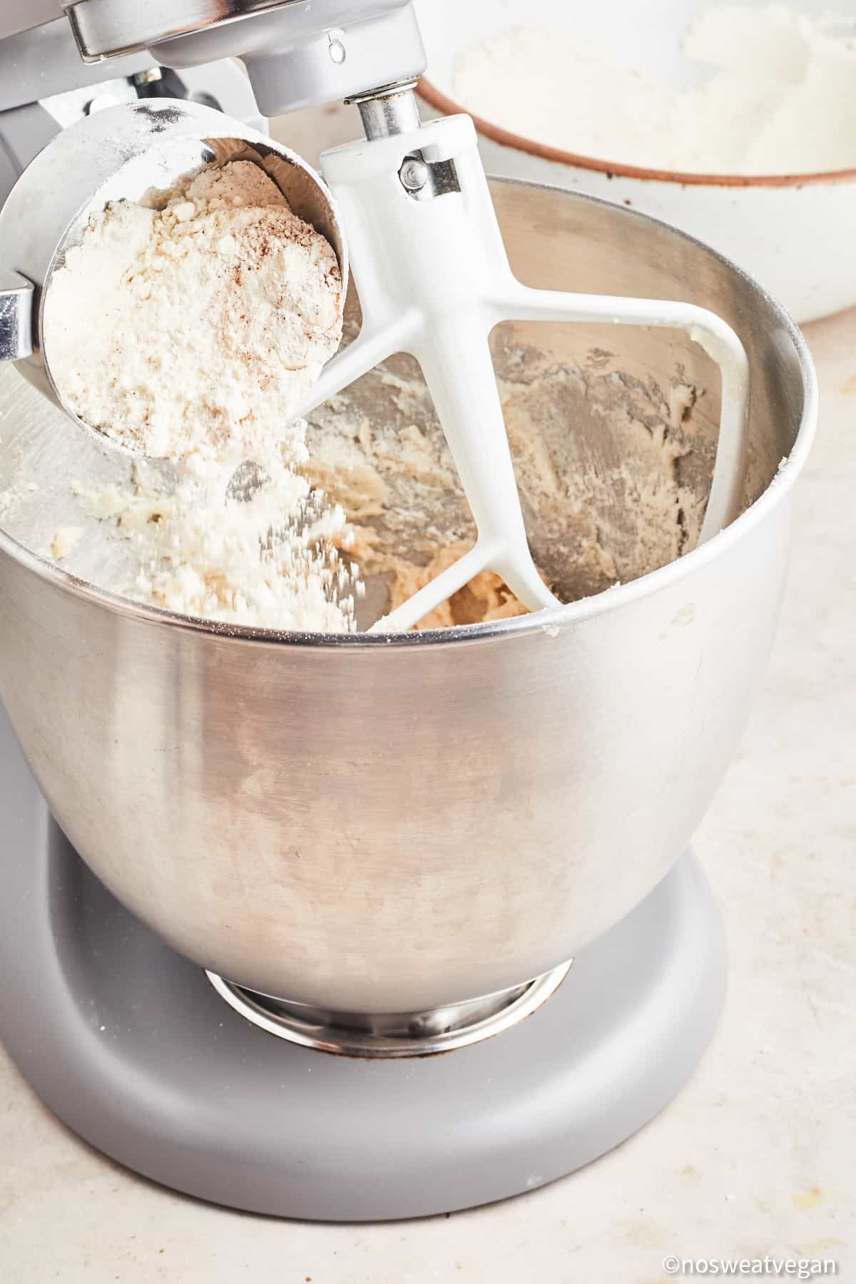 Adding flour to vegan snickerdoodle dough.