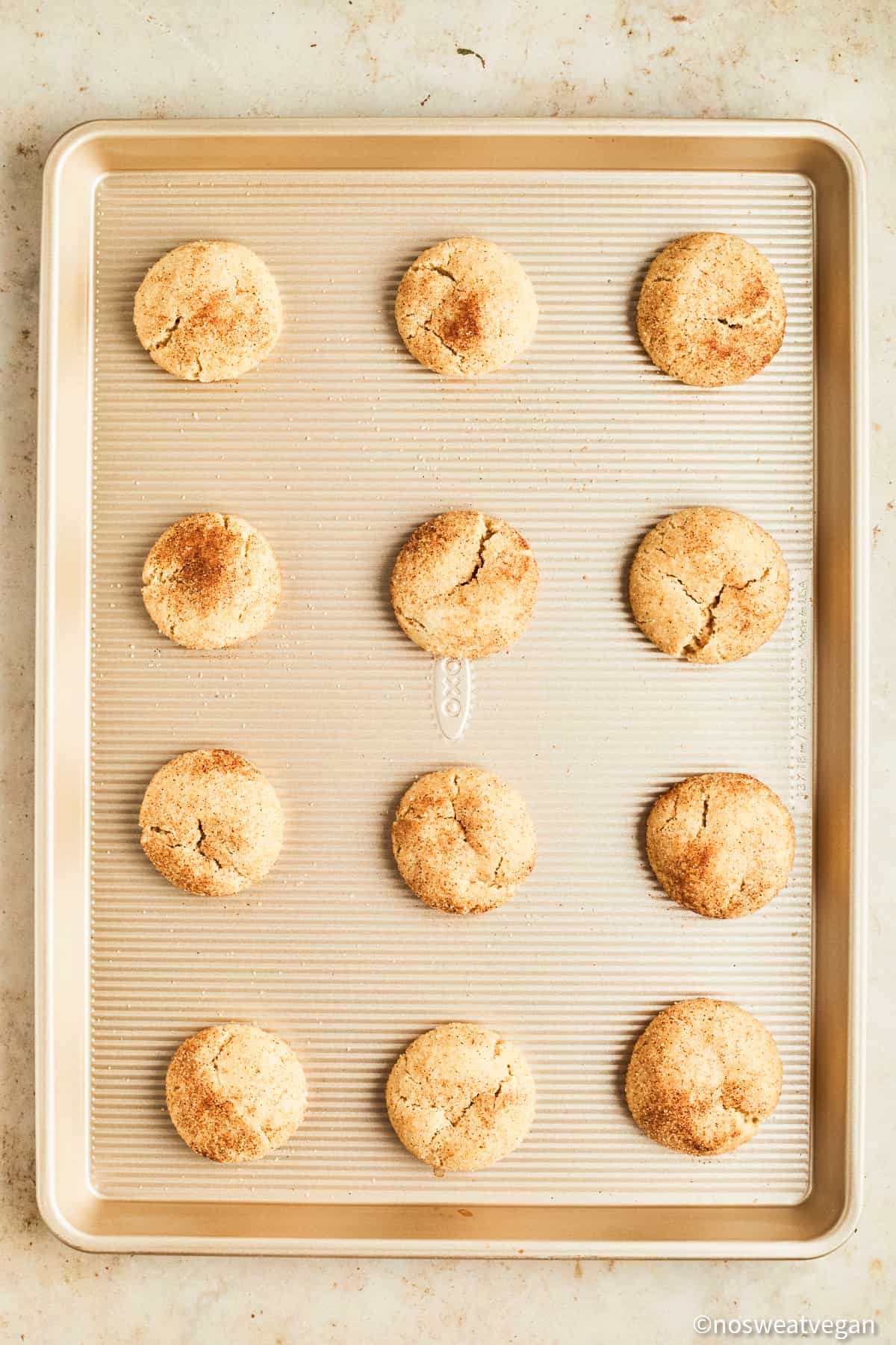 Vegan snickerdoodles baked on a cookie sheet.
