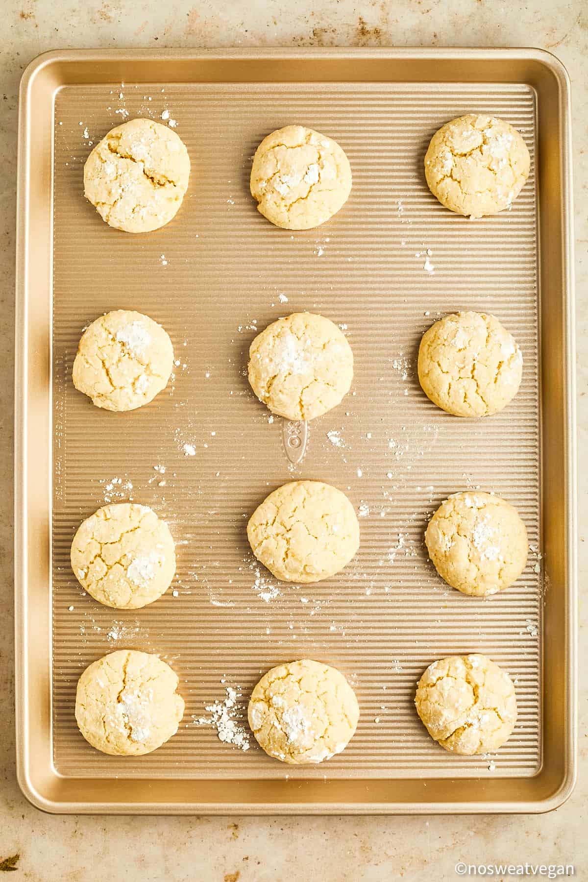 Vegan lemon cookies baked on a cookie sheet.