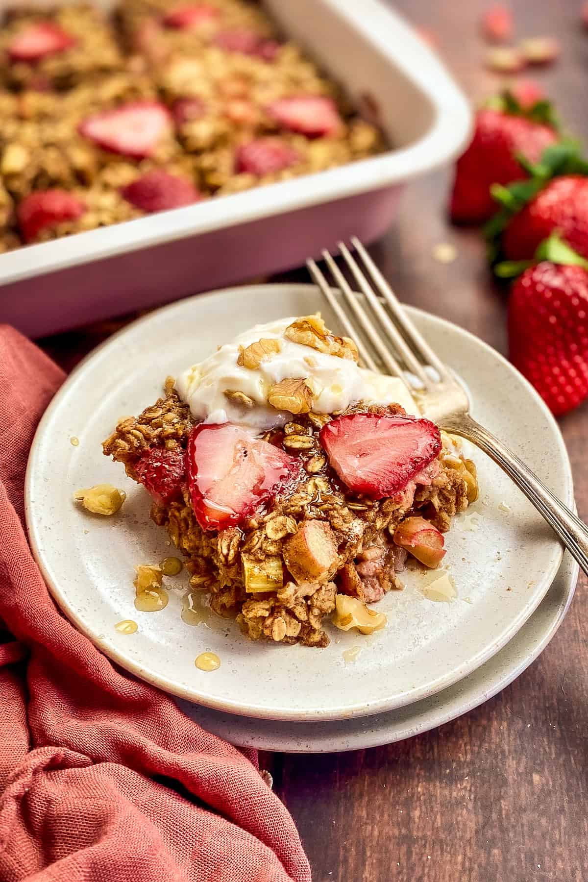 Strawberry rhubarb baked oats on a plate with a fork.