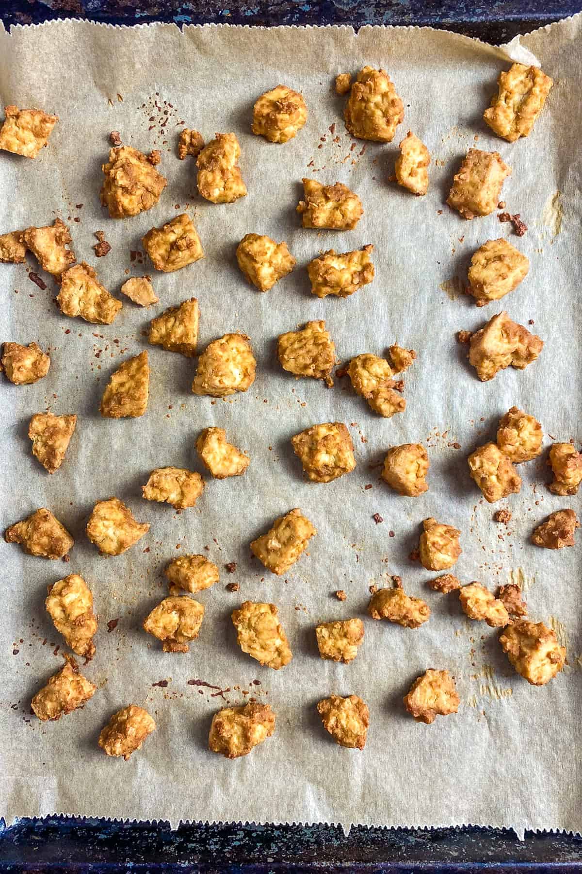 Baked buffalo tofu on a baking sheet.