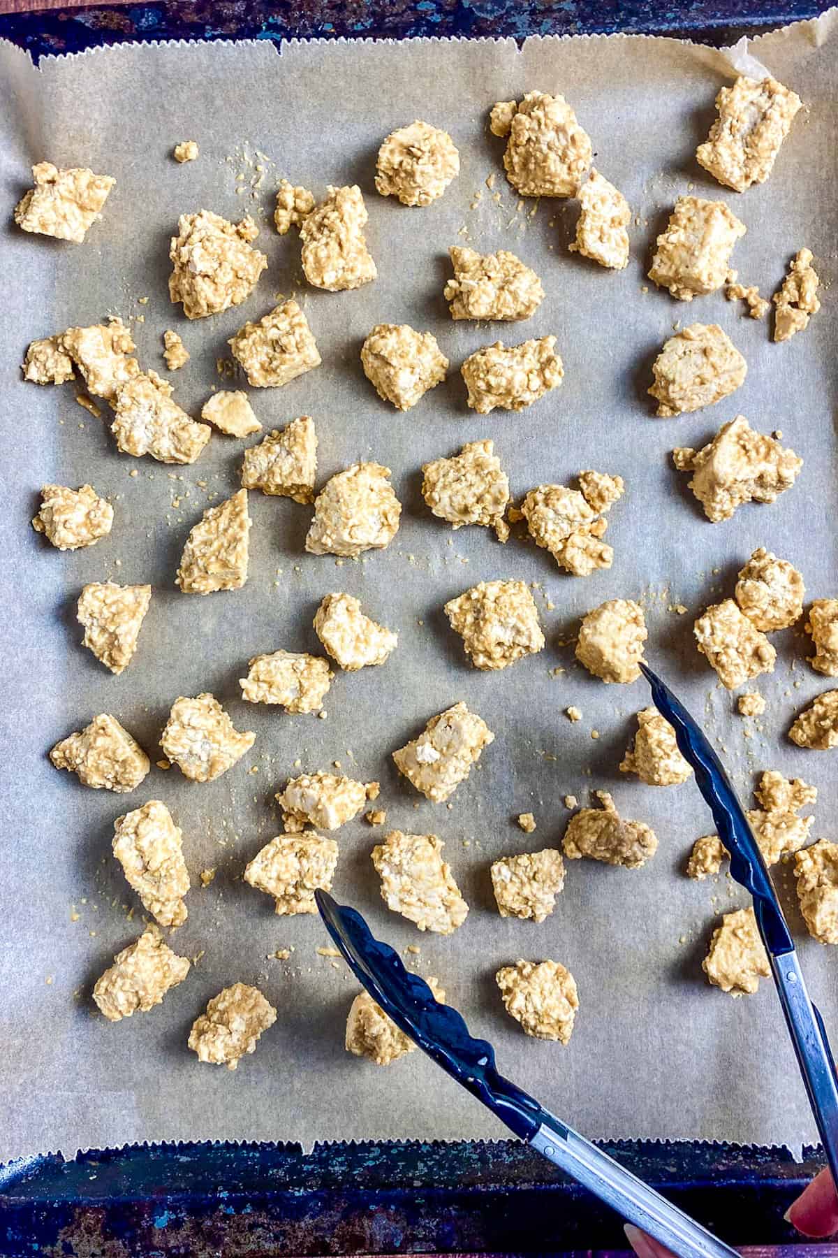 Buffalo tofu chunks on a baking sheet.